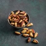 Peeled brazil nuts ib bowl on dark background